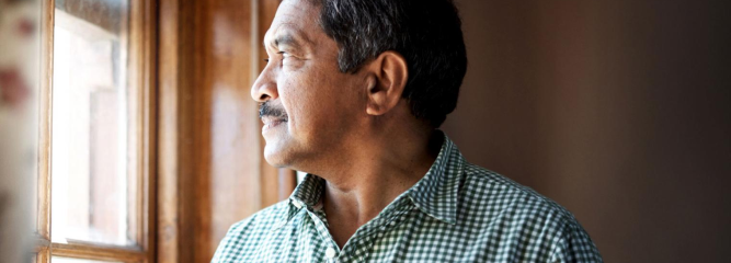 Muž dívající se z okna