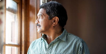 Muž dívající se z okna