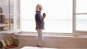 Žena u okna se šálkem kávy