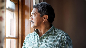 Muž dívající se z okna